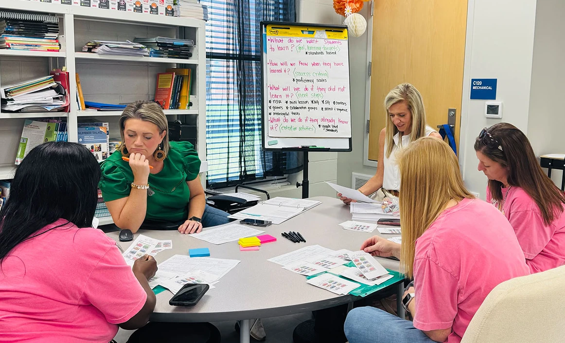 Kathryn Conradson, top right, meets with coworkers in her role as principal of Reeltown Elementary School.